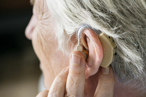 image depicting woman with hearing aid